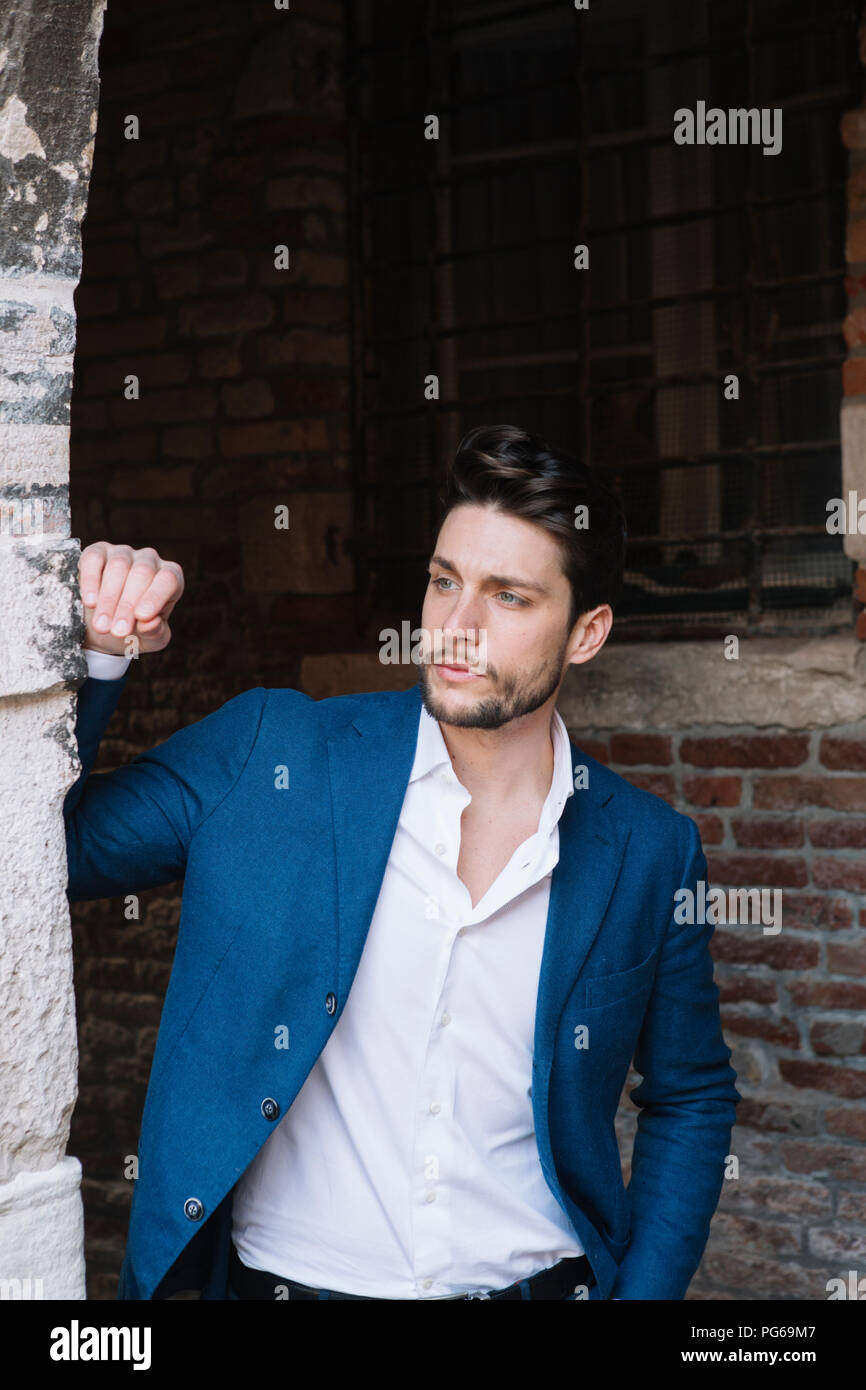 Elegante Mann an alten Backsteingebäude auf der Suche Stockfoto