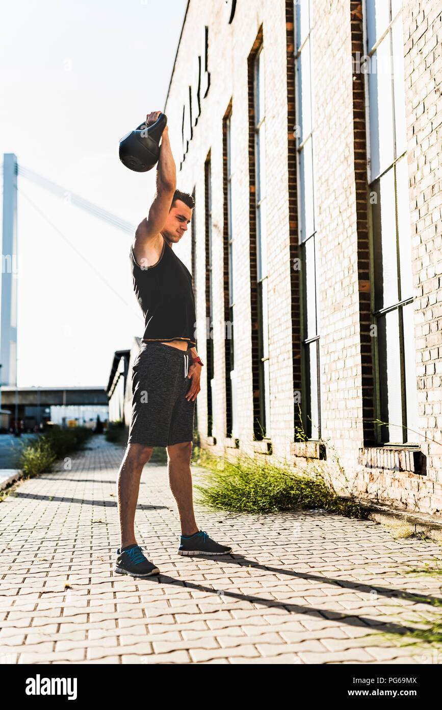 Junger Mann Training mit einem Wasserkocher bell Stockfoto