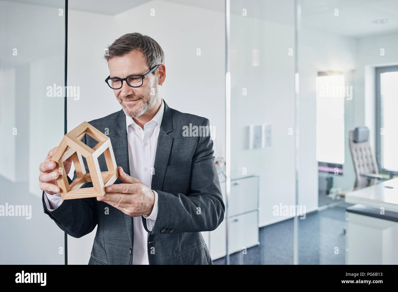 Lächelnd Geschäftsmann an architektonischen Modell im Büro suchen Stockfoto