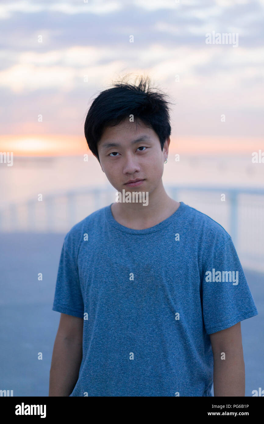 Junge Chinesen am Strand bei Sonnenaufgang, Porträt Stockfoto