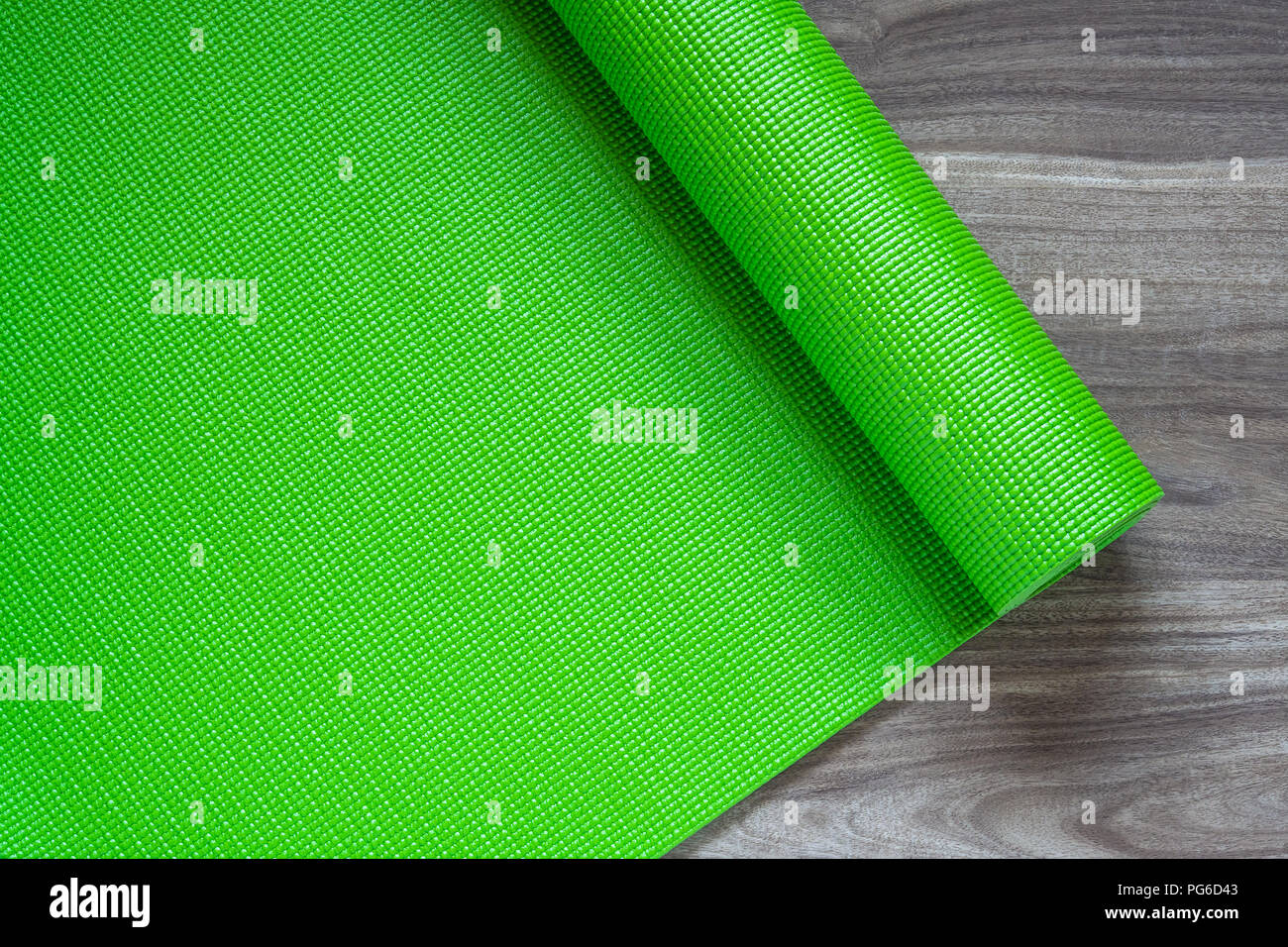 Grüne Yoga Matte auf einem hölzernen Hintergrund, Ansicht von oben mit der Kopie. Actie gesunder Lebensstil Hintergrund Konzept. Stockfoto