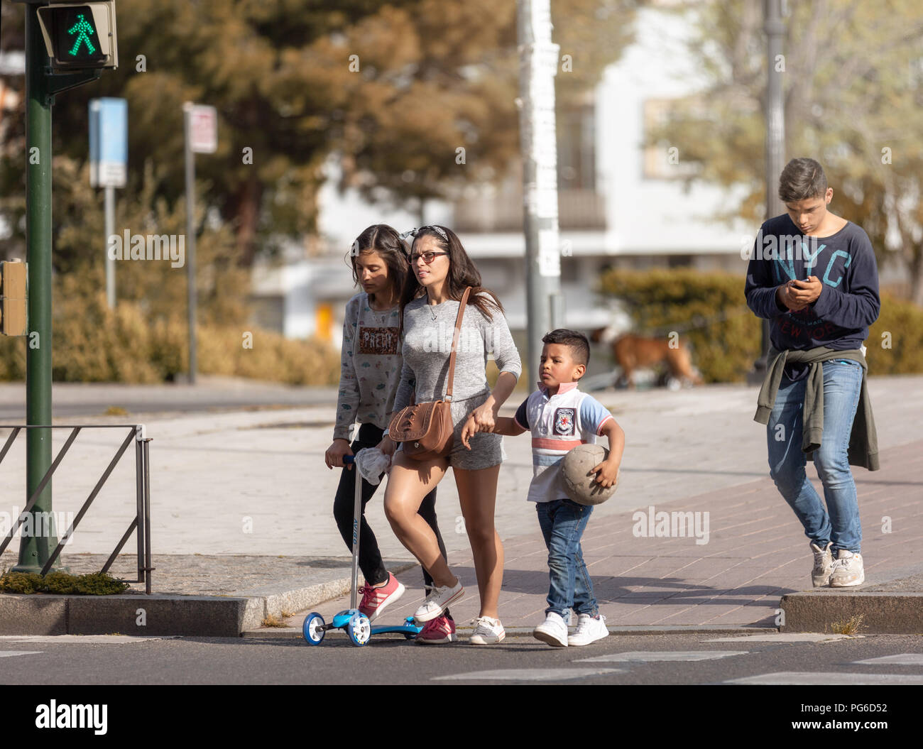Diese latino Familie beginnt, die Straße zu überqueren, wenn das grüne Symbol auf. Stockfoto