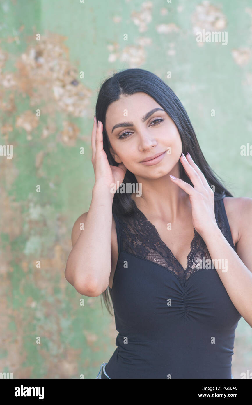 Schöne junge Frau mit den Händen berühren Gesicht im Freien Stockfoto