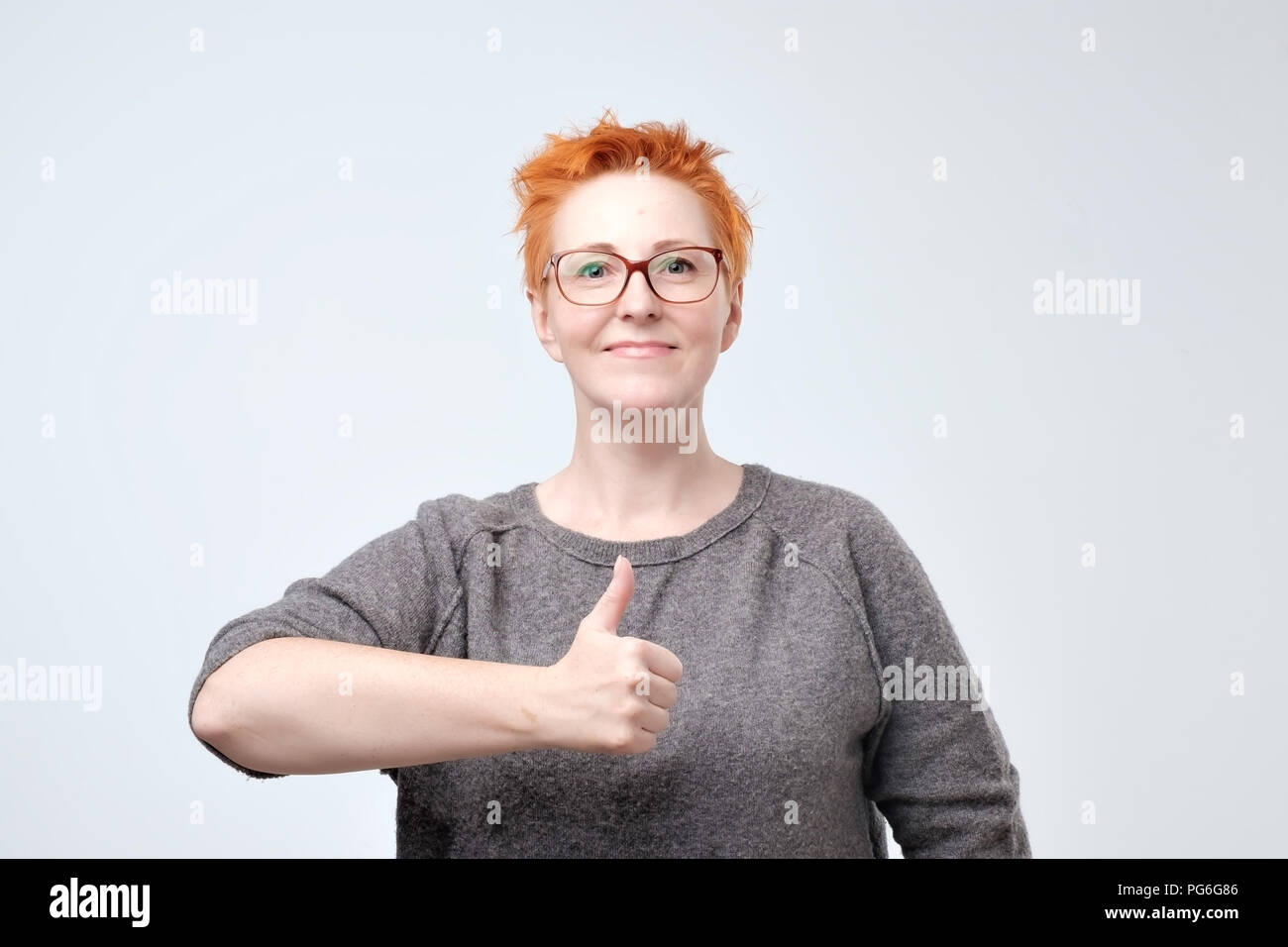 Ziemlich kaukasischen reife Frau mit roten Haaren, Daumen hoch über einem weißen Hintergrund isoliert Stockfoto