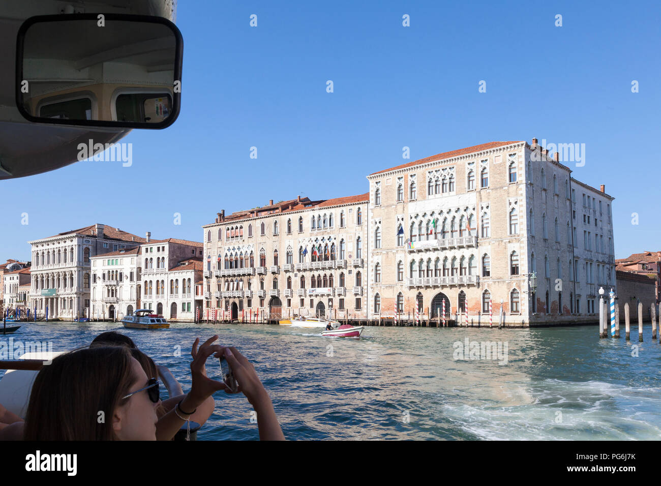 Frau touristische Reisen auf einem Vaporetto, Canale grande, Venedig, Venetien, Italien fotografieren Ca' Foscari Universität auf einem Smartphone, Erste Person Punkt Stockfoto