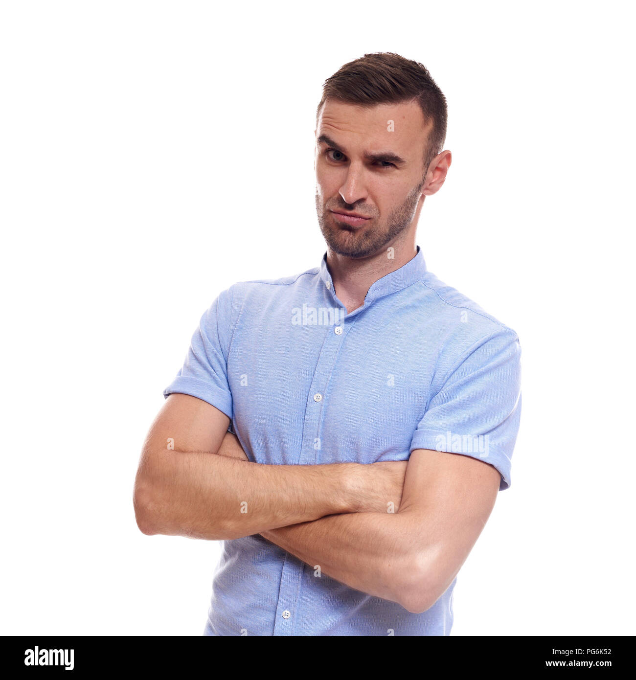 Beiläufig stattlich. Selbstbewussten jungen gutaussehenden Mann in Jeans shirt halten die Arme verschränkt und lächelnd, während gegen den weißen Hintergrund stehen. Stockfoto