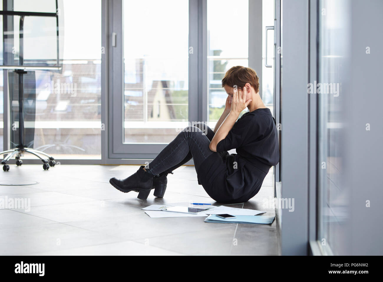 Überbeansprucht Geschäftsfrau, sitzen auf dem Boden im Büro Stockfoto