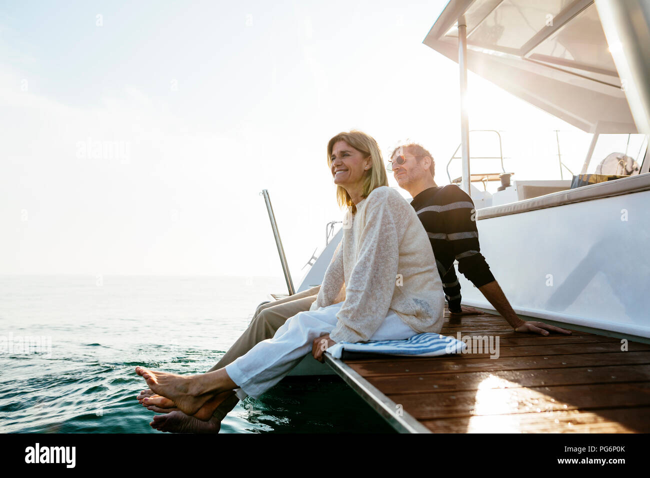 Reifes Paar sitzt auf Jetty, Entspannen am Meer Stockfoto