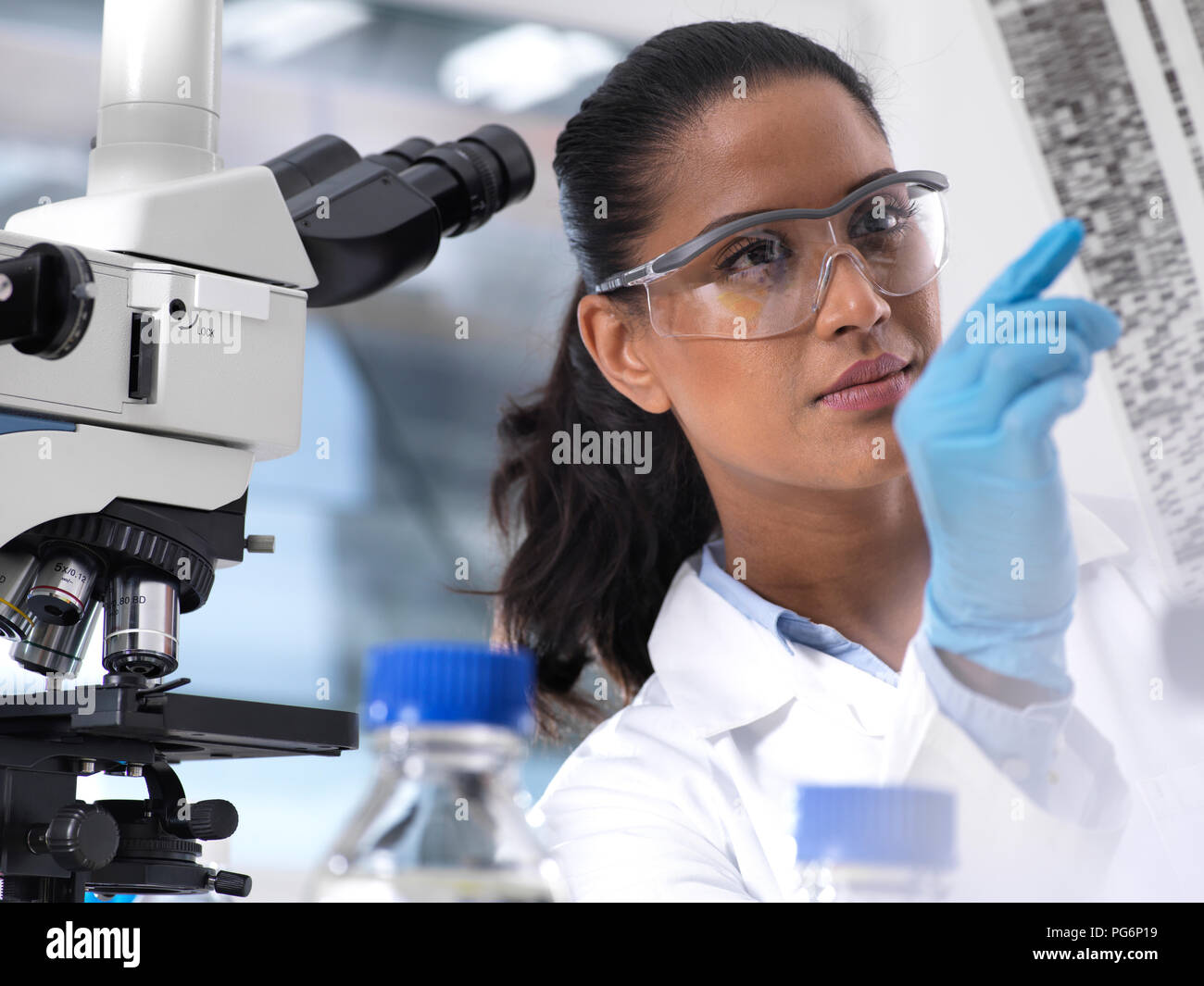 Die genetische Forschung, weibliche Wissenschaftler eine Folie mit genetischen Code, die genetischen Make-up Stockfoto