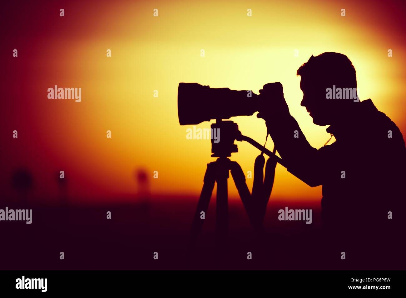 Goldene Stunde Fotografie. Silhouette von Männern, die Bilder mit großen Teleobjektiv. Stockfoto