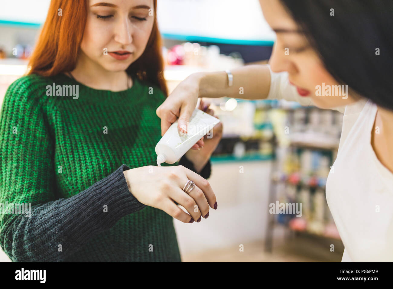 Zwei Frauen in einem kosmetik Shop versuchen, Hand Creme Stockfoto