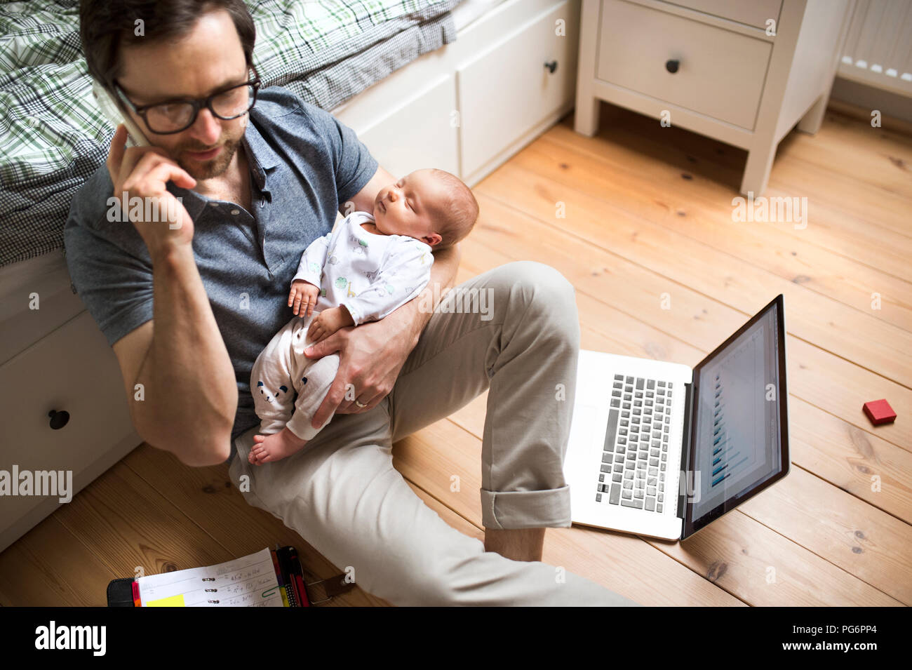 Vater mit seiner Tochter, die von zu Hause aus arbeiten Stockfoto