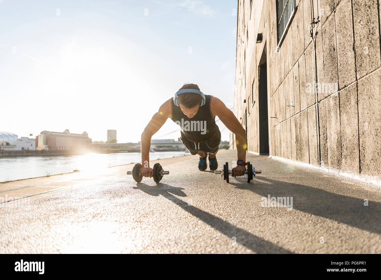 Fit Sportler tun Push-ups am Fluss Stockfoto