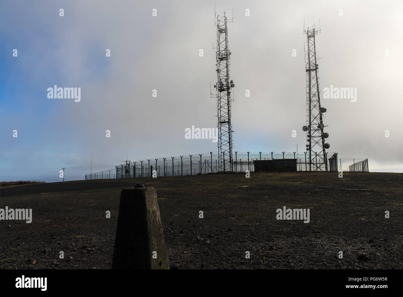Telekommunikation Masten auf dem Gipfel des Berges mit Divis trig Point im Vordergrund. Belfast, Nordirland. Stockfoto