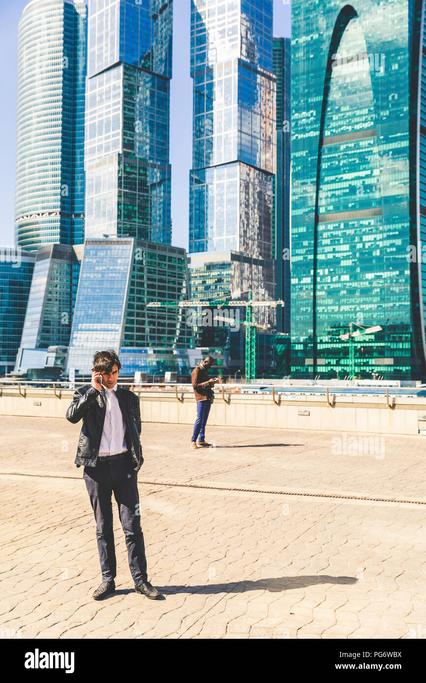 Russland, Moskau, zwei Geschäftsmänner mit Handys in der Stadt Stockfoto