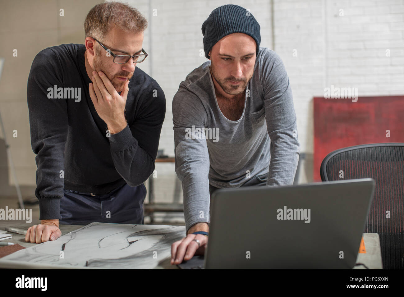 Artist mit Laptop mit Mann im Studio Stockfoto