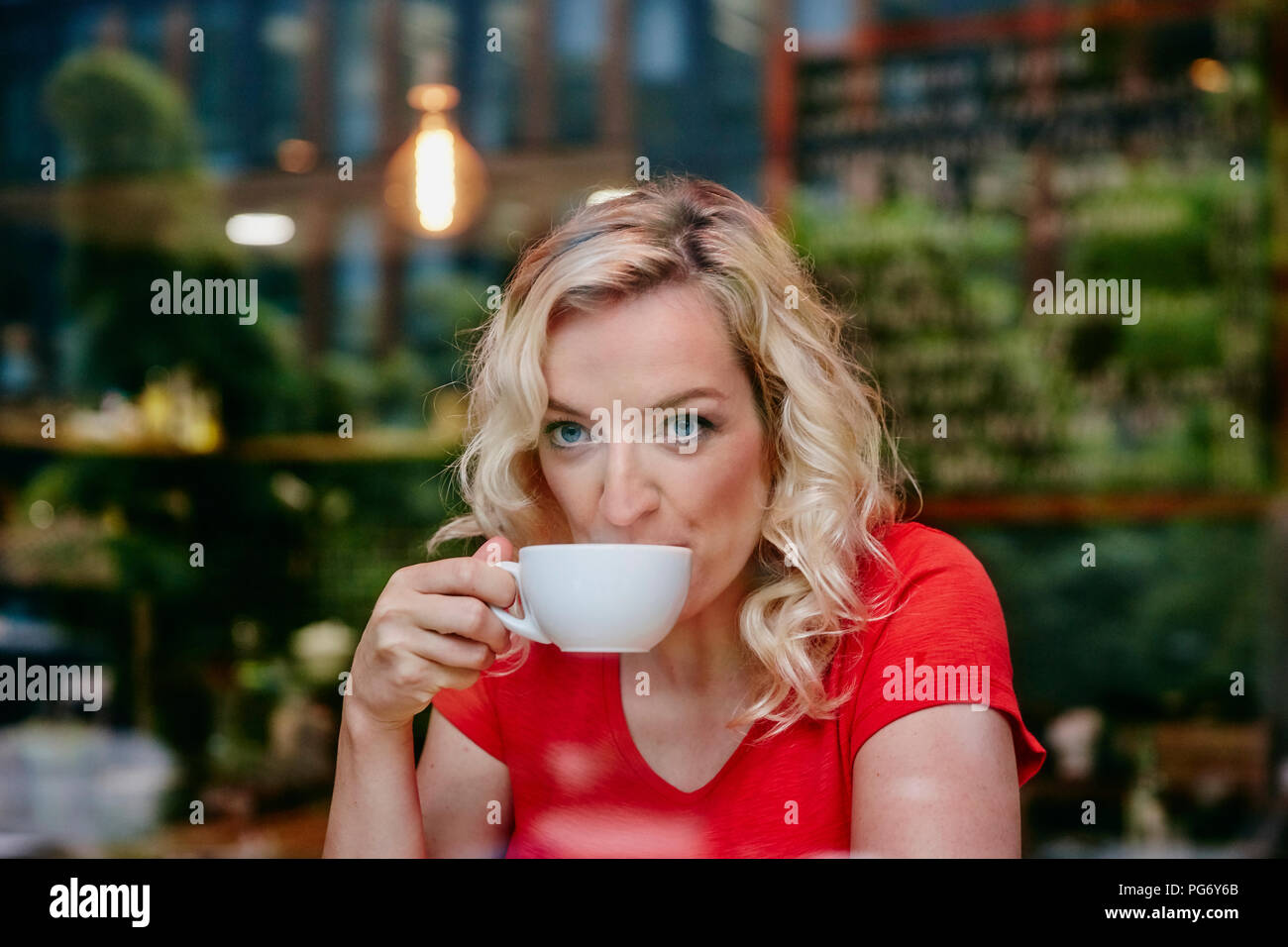 Portrait der blonden Frau trinkt Kaffee in einem Cafe Stockfoto