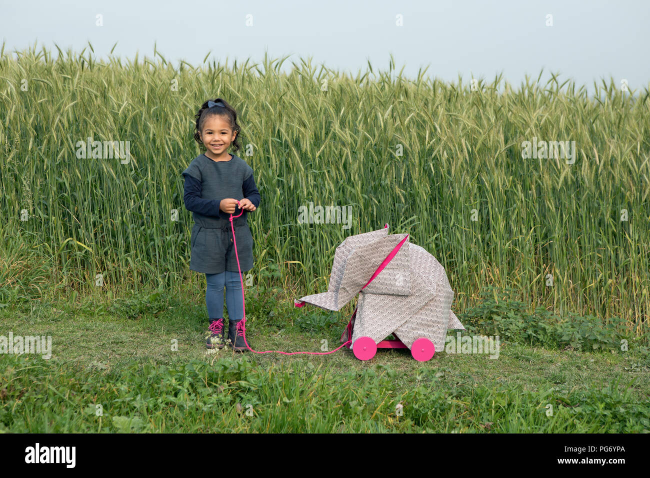 Kleines Mädchen mit Origami Elefant im Feld Stockfoto