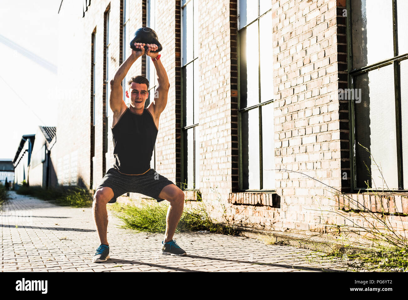 Junger Mann Training mit einem Wasserkocher bell Stockfoto