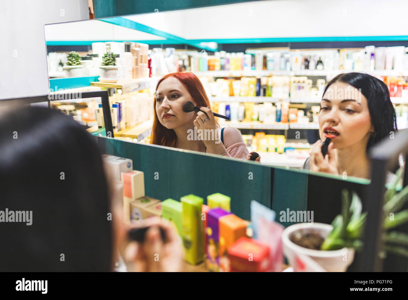 Zwei Frauen in einem kosmetik Shop versuchen, bilden. Stockfoto