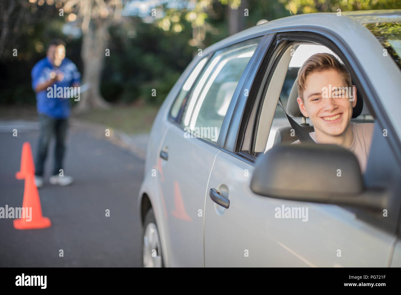 Lächelnd Fahrschüler lernen zu fahren im Rückspiegel eines Autos suchen Stockfoto