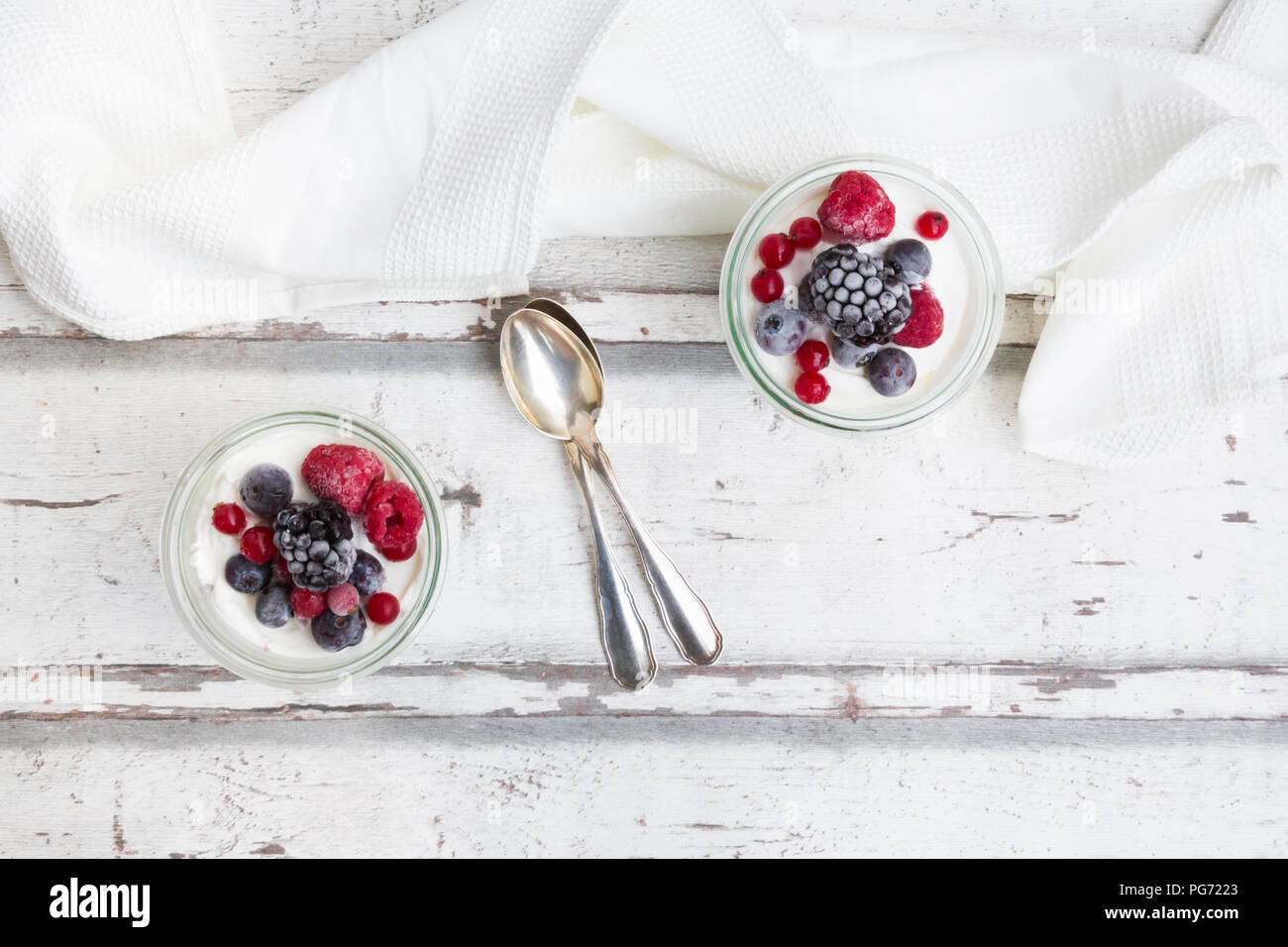 Zwei Gläser griechischer Joghurt mit gefrorenen Beeren Stockfoto