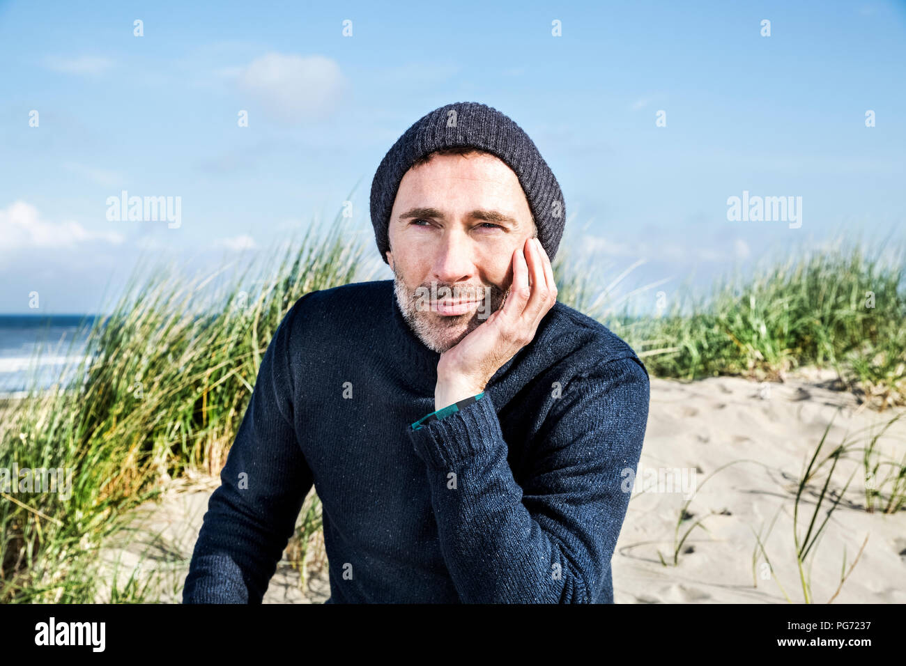 Porträt der Mann mit wollmütze am Strand Stockfoto