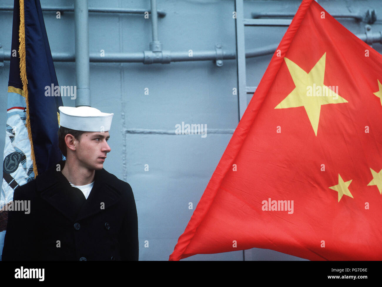 Ein US-Besatzung steht neben einem Chinesischen Flagge während einer port Besuch der Lenkwaffen-kreuzer USS REEVES (CG24), die lenkwaffenfregatte USS RENTZ (FFG 46) und der Zerstörer USS OLDENDORF (DD 972). Stockfoto
