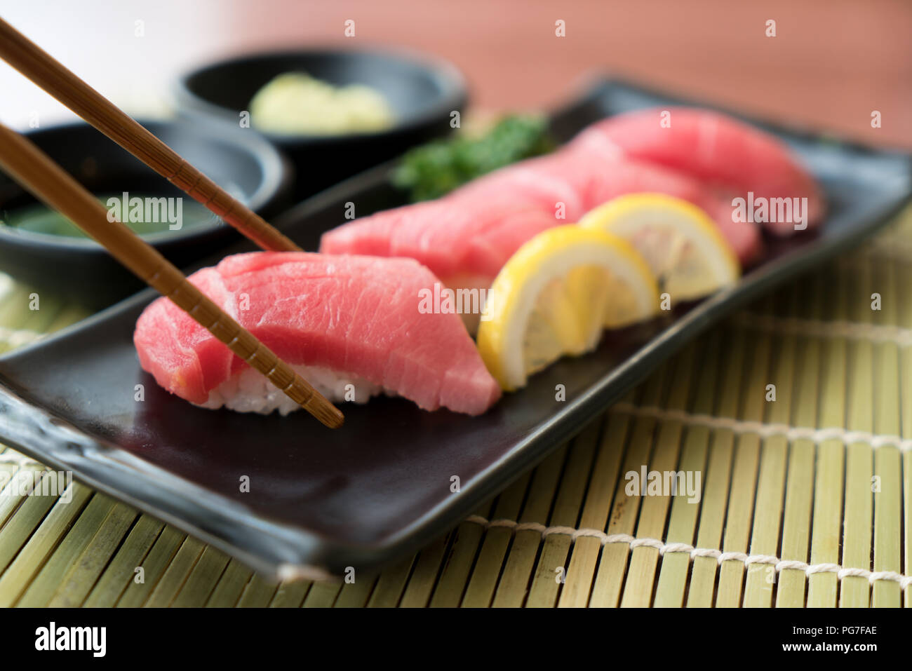 Otoro Thunfisch Sushi auf schwarze Platte zusammen mit japanischen Sauce und green leaf Dekoration, Japanisches Essen, Sushi zu schließen. Stockfoto