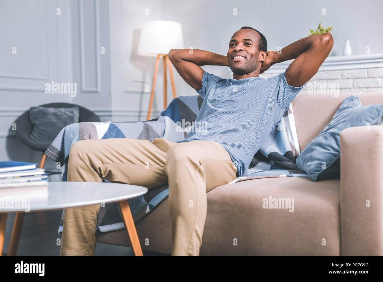 Lächelnde Menschen auf dem Sofa sitzt. Stockfoto