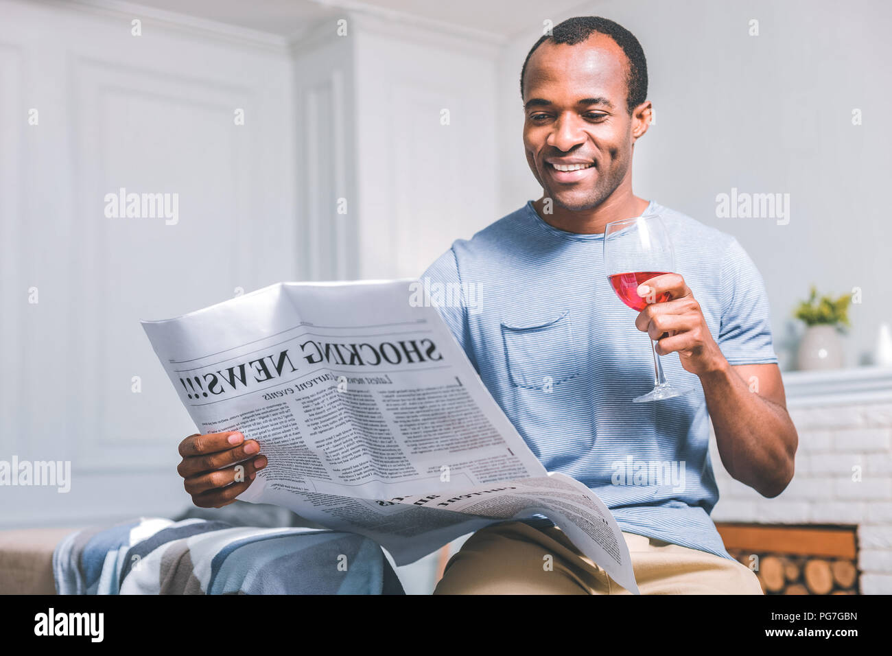 Fröhlicher Mann hält eine Zeitung Stockfoto