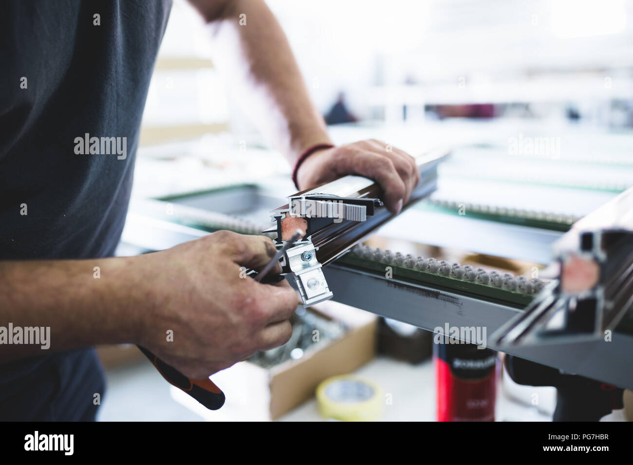 Fabrik für Aluminium- und PVC-Herstellung von Türen und Fenstern. Arbeiter Montage PVC-Türen und Fenster. Stockfoto