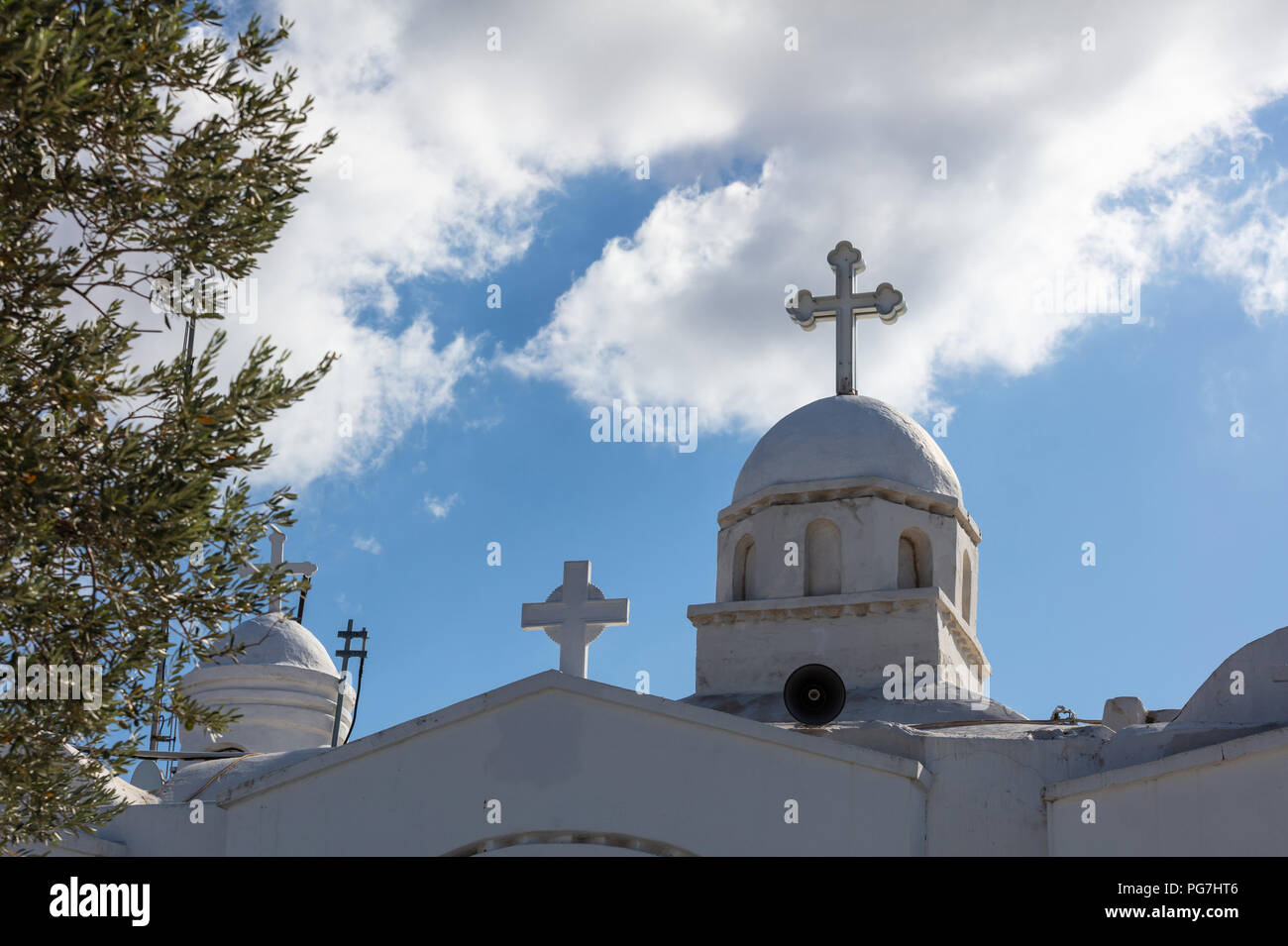 Kirche mit weißen Kuppel in Athen Griechenland, auf dem Hintergrund des blauen Himmels und Olivenbaum im Vordergrund. Stockfoto