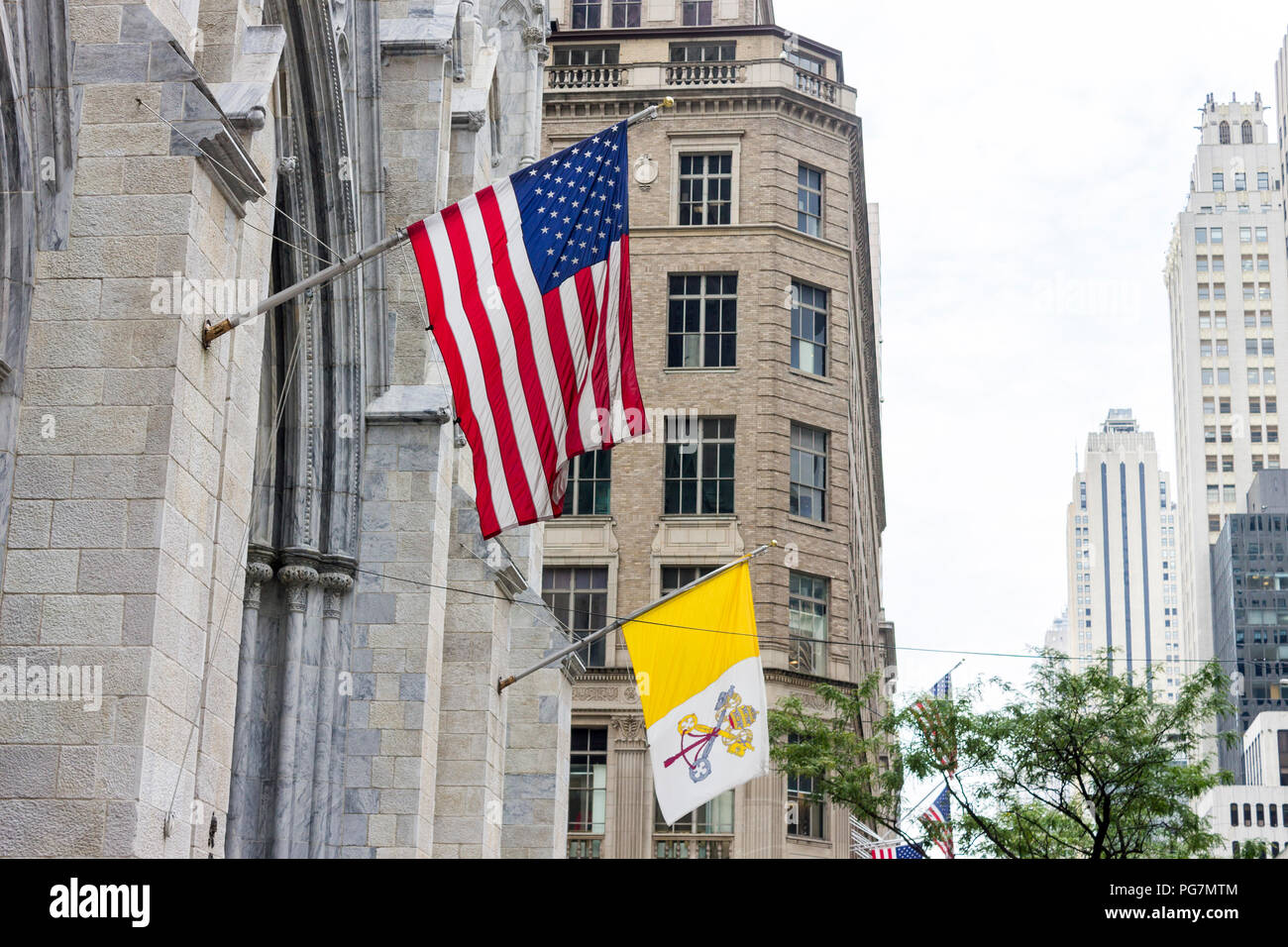 New York City. Flagge der Vereinigten Staaten von Amerika und der Staat Vatikanstadt hängen von der Hauptfassade der St. Patrick's Cathedral in Manhattan Stockfoto