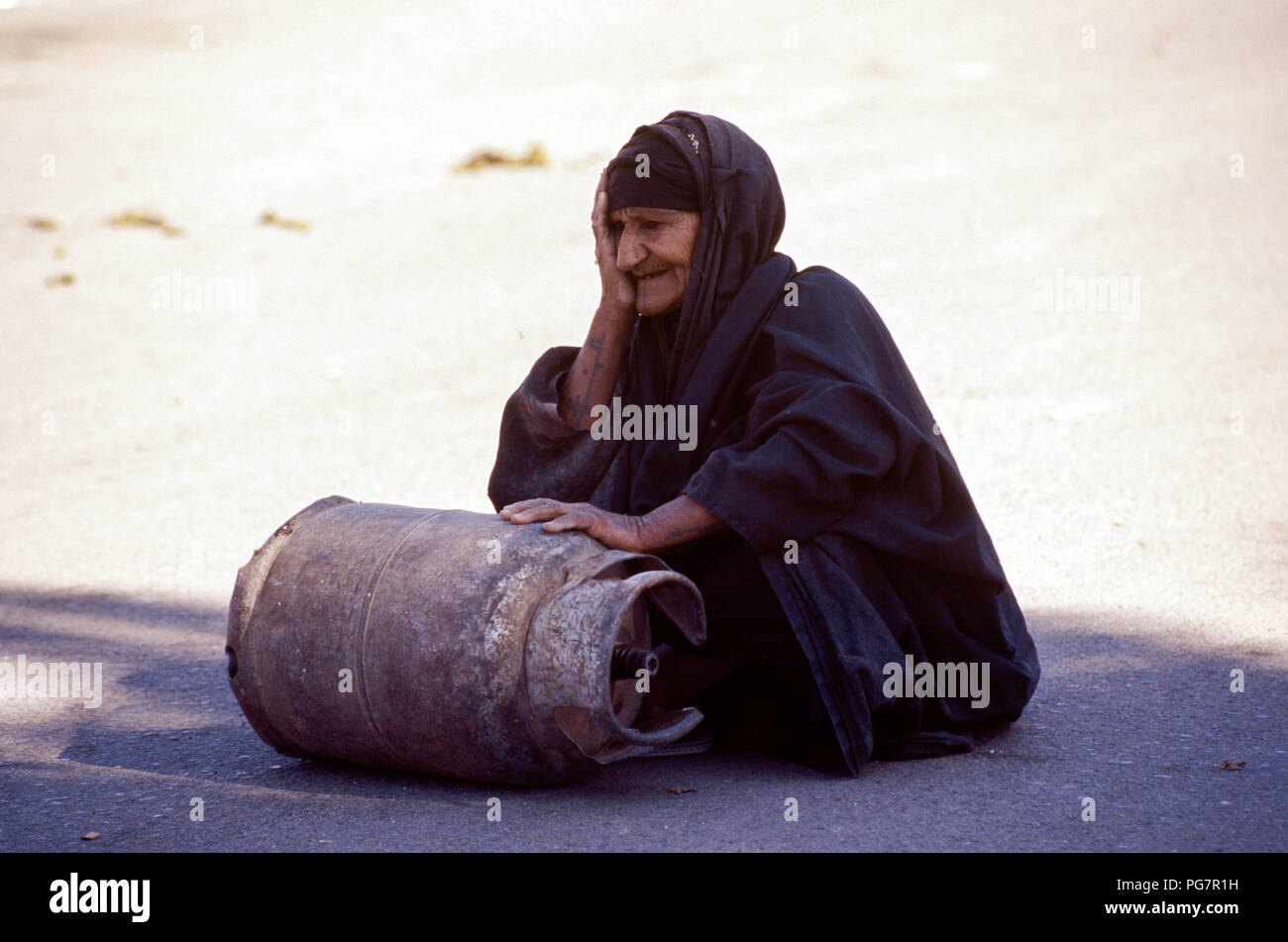 Bagdad, Irak - Oktober 1995 - Eine ältere irakische Frau rollt eine Butan Zylinder in der Straße Markt im Zentrum von Bagdad. Von Irakischen aufgrund der strengen UN-Sanktionen in den 90er kämpfen auferlegt, weil der irakischen Invasion in Kuwait im Jahr 1990. Stockfoto