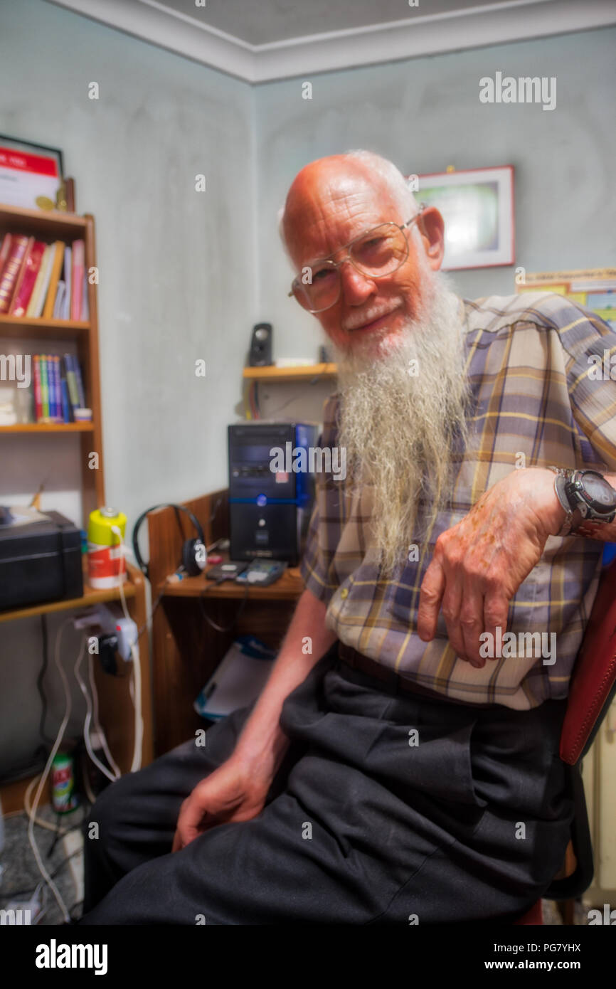 Alter Mann glücklich und zuversichtlich mit Computern Stockfoto