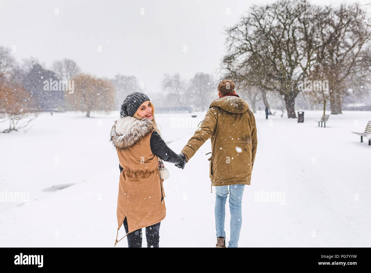 Happy Teenager Flanieren mit ihren Freund im Park auf Schnee Tag Stockfoto