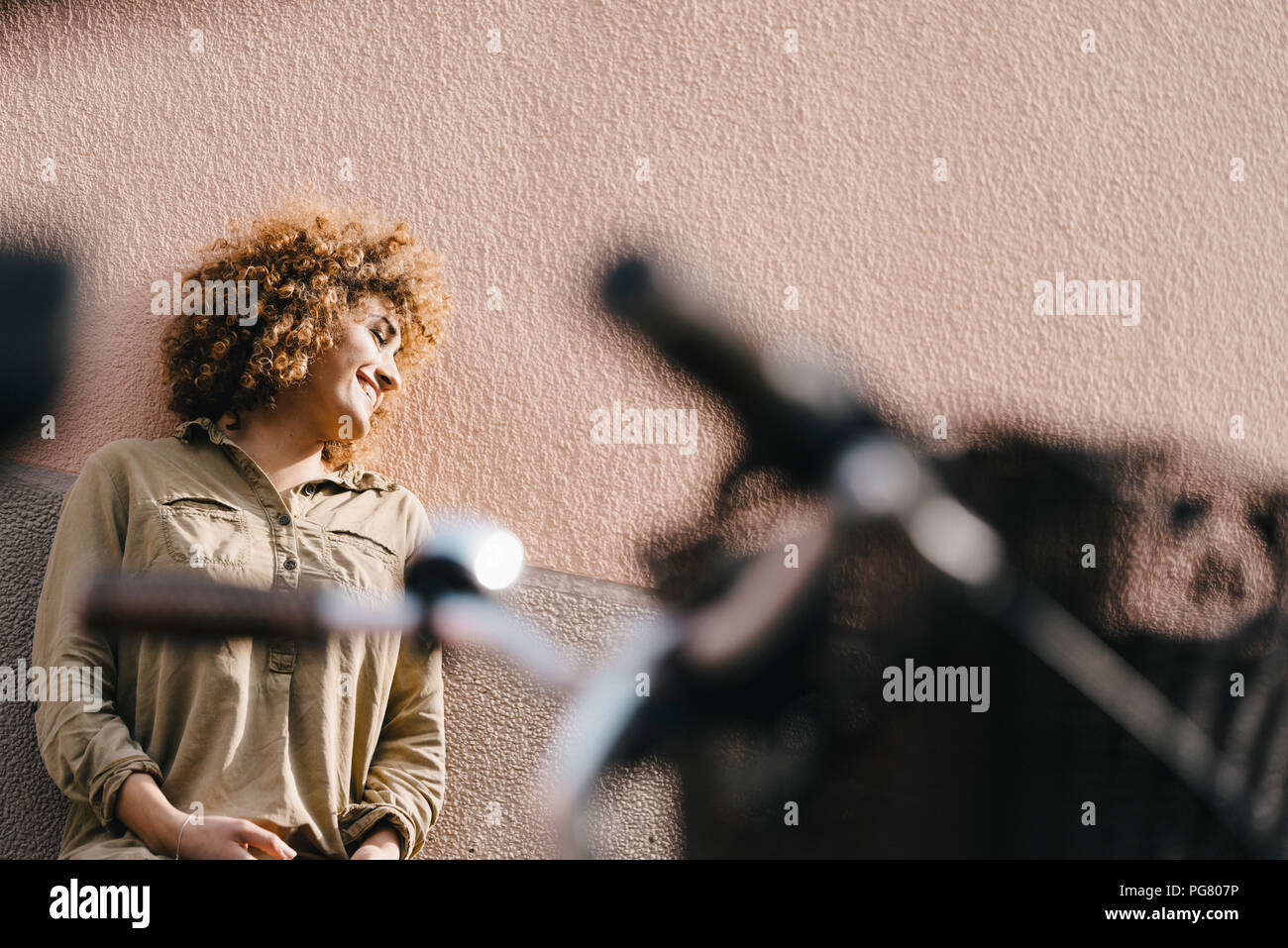 Lachende Frau vor der Hauswand, die Sonne genießen Stockfoto