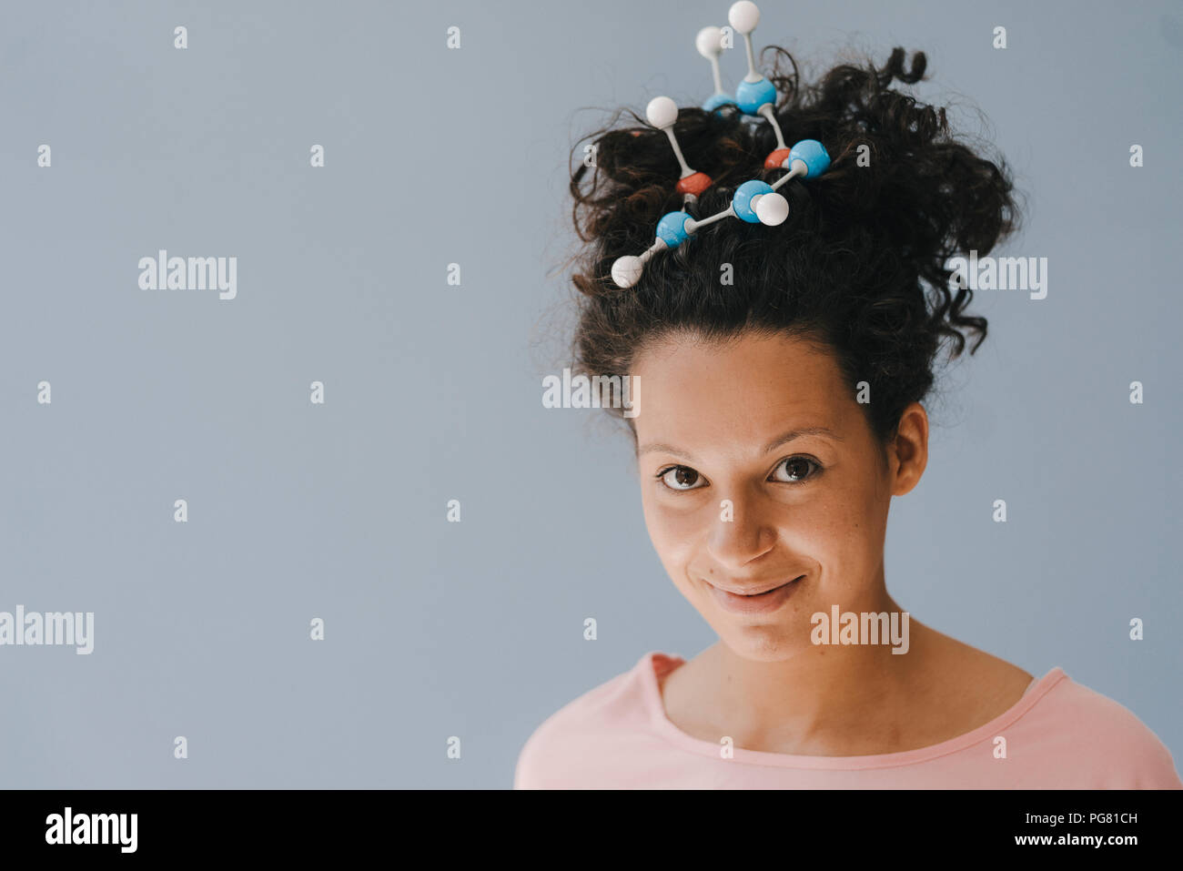 Junge Frau mit Molekül Modell im Haar Stockfoto