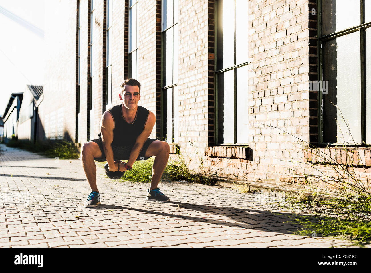 Junger Mann Training mit einem Wasserkocher bell Stockfoto