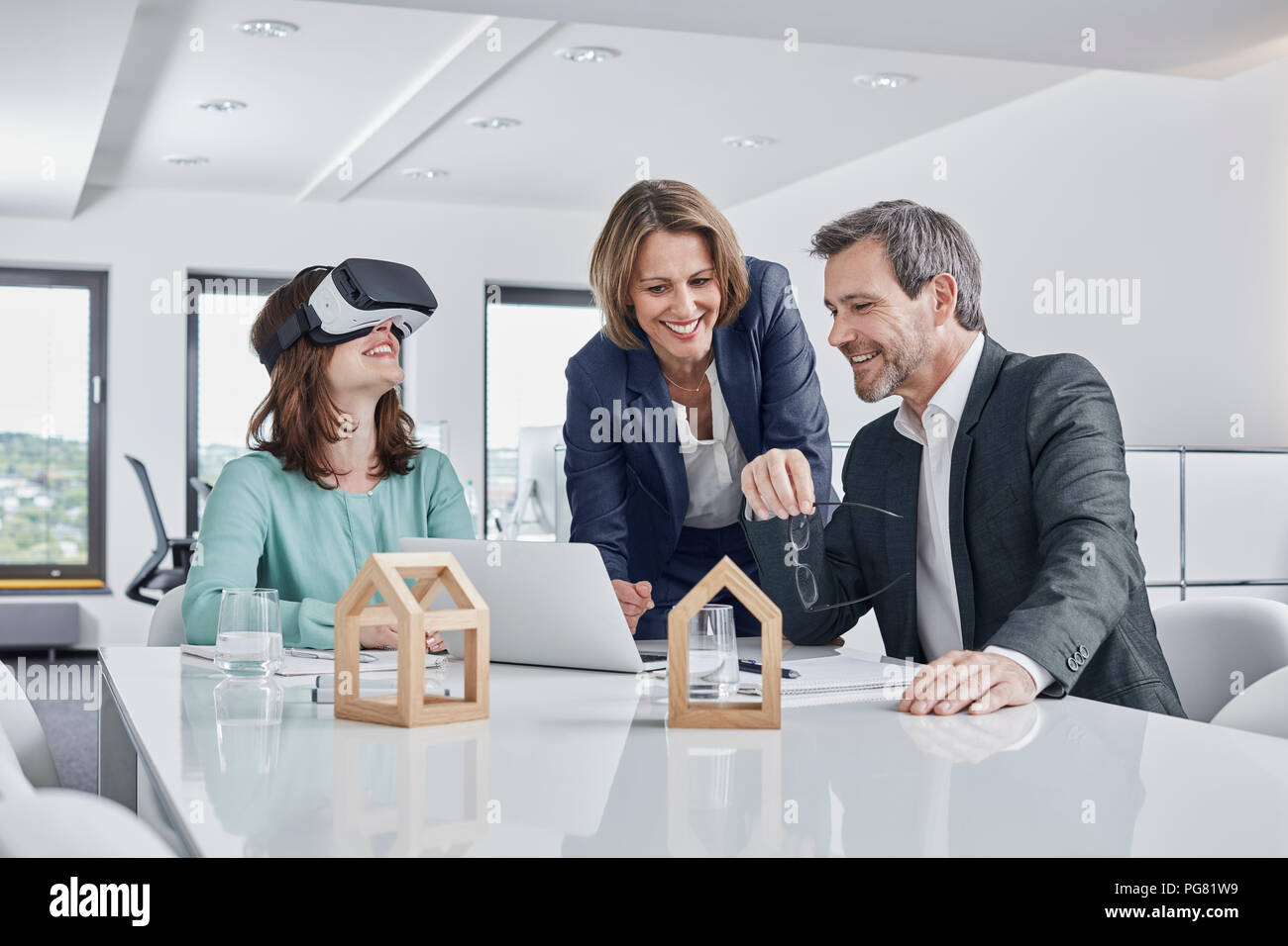 Geschäftsleute in einer Sitzung im Büro mit VR-Brille, Laptop und architektonische Modelle Stockfoto