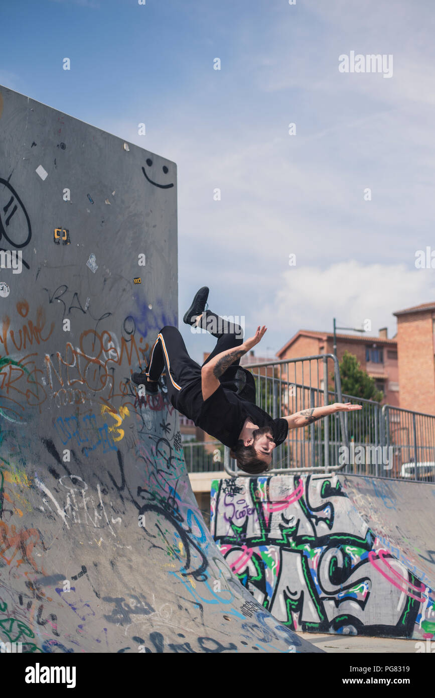 Tätowierten Mann tun Parkour in einem Skatepark Stockfoto
