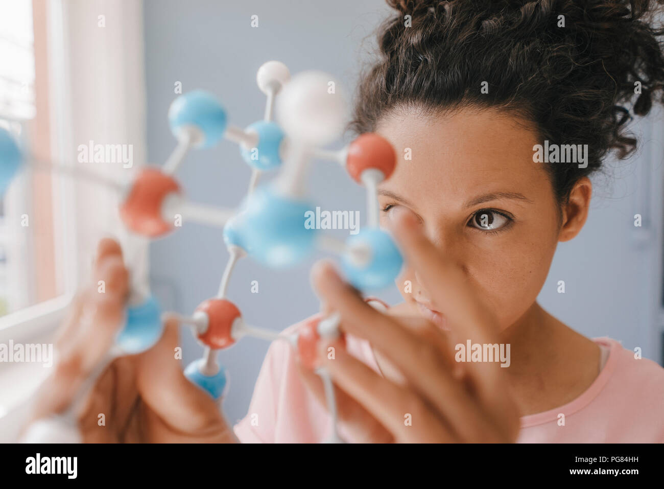 Wissenschaftlerin holding Molekülmodell, suchen Sie nach Lösungen Stockfoto