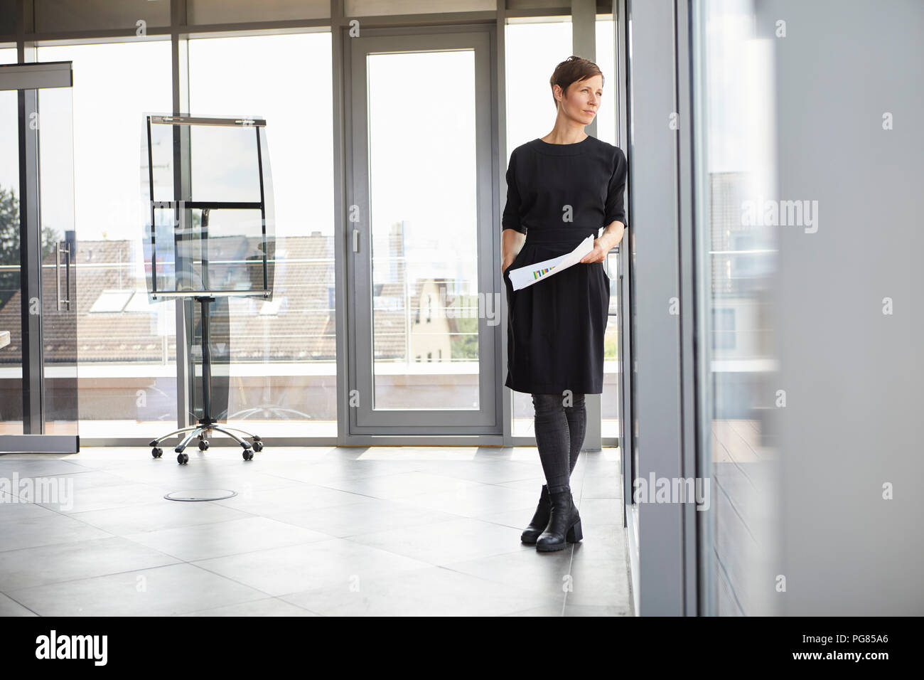 Geschäftsfrau im Büro Blick aus Fenster Stockfoto