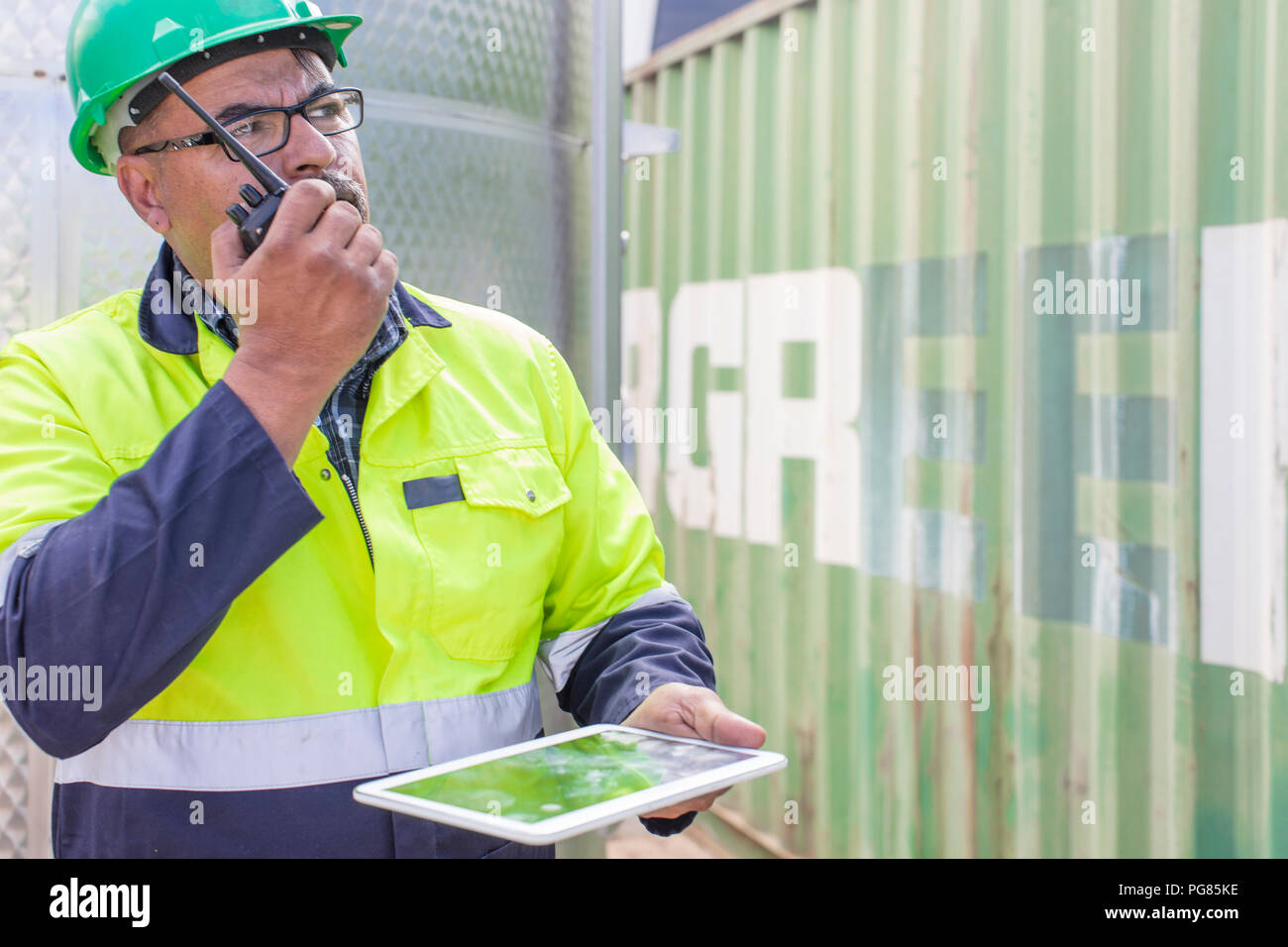 Arbeiter mit Tablet das Tragen von Warnwesten mit Walkie talkie am Container Stockfoto