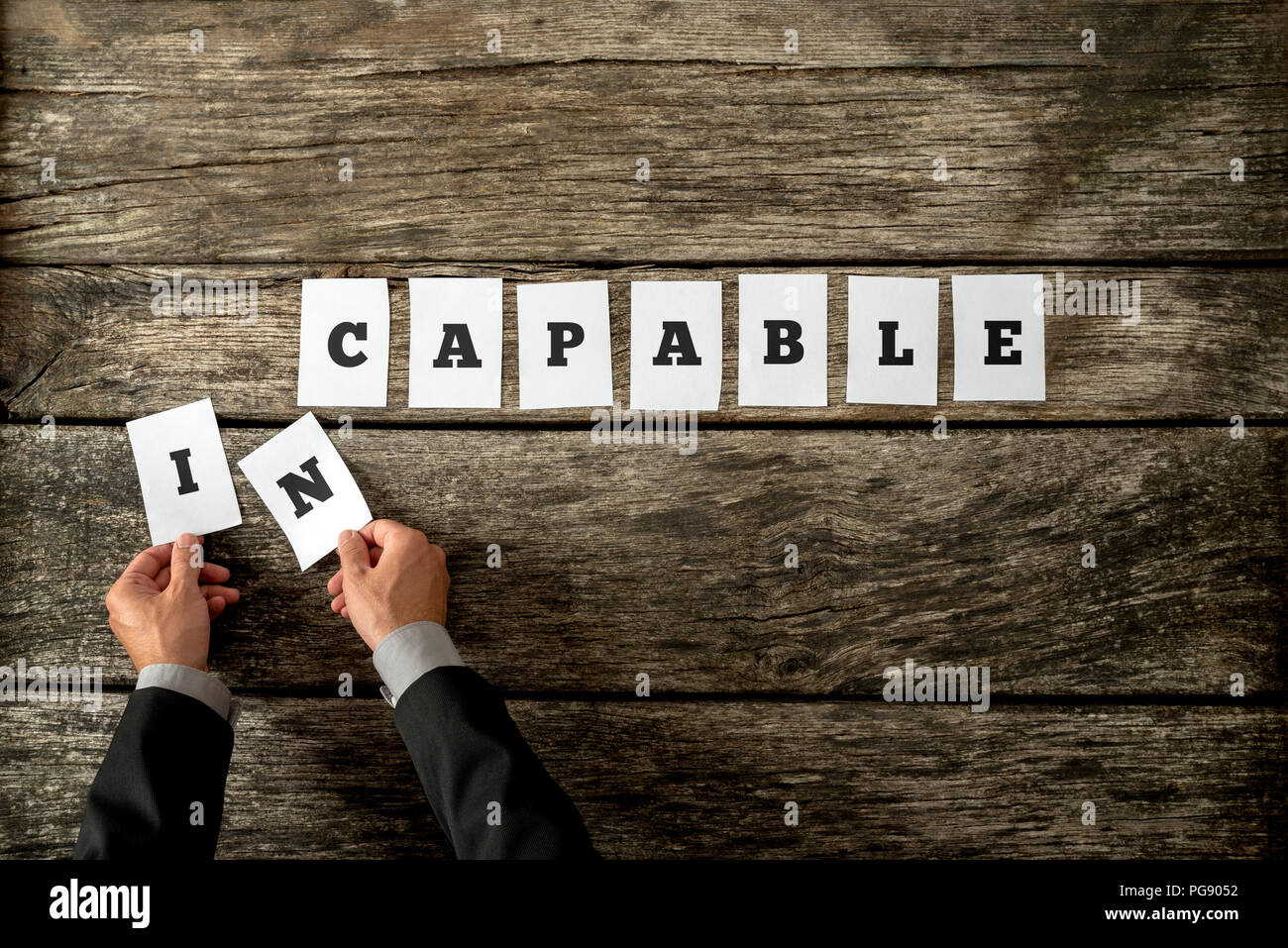 Ansicht von oben persönlicher Motivator oder Berater Buchstaben entfernen, von dem Wort unfähig es zu ändern in der Lage. Konzept der persönlichen Transformation Stockfoto