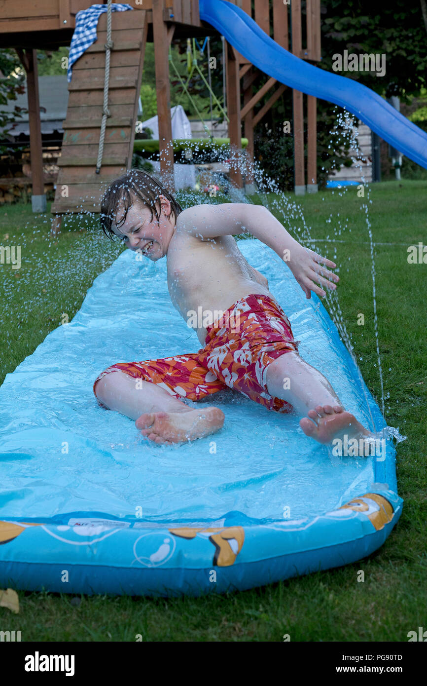 Junge auf Wasserrutsche, Neuenkleusheim, Olpe, Nordrhein-Westfalen, Deutschland Stockfoto