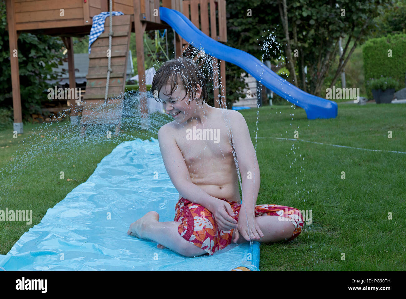 Junge auf Wasserrutsche, Neuenkleusheim, Olpe, Nordrhein-Westfalen, Deutschland Stockfoto