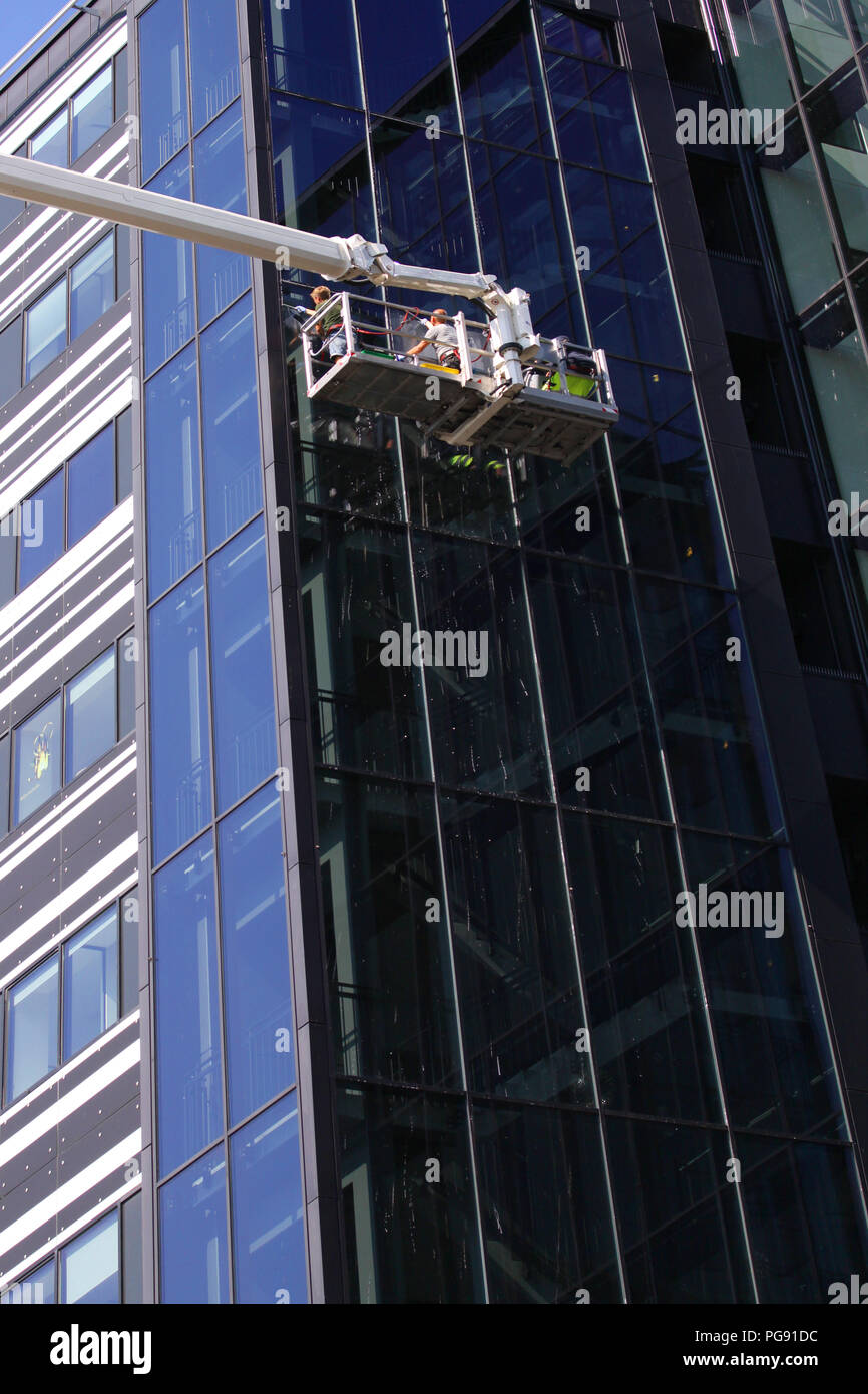 Fensterreiniger arbeiten an ein modernes hohes Gebäude aus Glas Stockfoto