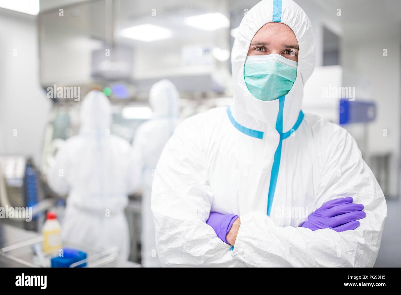 Labortechniker tragen ein Schutzanzug und Gesichtsmaske im Labor, die in einem sterilen Umgebung erhalten. Stockfoto